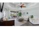 Bright living room with modern decor, ceiling fan, and sliding glass doors leading to outdoor dining area at 135 Cabana Way, Rotonda West, FL 33947