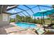 A screened-in pool with outdoor seating offers the perfect place to relax and enjoy the Florida sunshine at 135 Cabana Way, Rotonda West, FL 33947