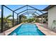 Screened-in pool with brick surround, steps into the pool, and lounge chairs around it at 135 Cabana Way, Rotonda West, FL 33947