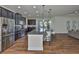 Open kitchen features stainless steel appliances, dark cabinets, granite counters, and an island with bar seating at 13908 Artesa Bell Dr, Riverview, FL 33579