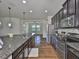 Modern kitchen features dark cabinets, granite countertops, stainless steel appliances, and wood-look floors at 13908 Artesa Bell Dr, Riverview, FL 33579