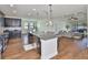 Bright open-concept kitchen flows into a living room with dark cabinets and stainless steel appliances at 13908 Artesa Bell Dr, Riverview, FL 33579