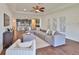 Spacious living room with ceiling fan open to the kitchen with stainless appliances and island seating at 13908 Artesa Bell Dr, Riverview, FL 33579