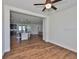 Open-concept living area with hardwood floors and view of the modern kitchen at 13908 Artesa Bell Dr, Riverview, FL 33579