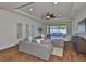 Open living room with a large gray couch, fan, and large glass sliding doors to outdoor patio at 13908 Artesa Bell Dr, Riverview, FL 33579
