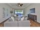 Open living room with a large gray couch, fan, and large glass sliding doors to outdoor patio at 13908 Artesa Bell Dr, Riverview, FL 33579