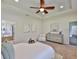 Spacious main bedroom boasts tray ceiling, fan, and seating area near the ensuite bath at 13908 Artesa Bell Dr, Riverview, FL 33579
