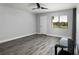 Spacious bedroom featuring grey flooring, ceiling fan and large window overlooking a green space at 142 Lakeview Way # 142, Oldsmar, FL 34677