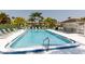 Beautiful pool with clear blue water, lounge chairs, and tropical foliage, creating a relaxing oasis at 142 Lakeview Way # 142, Oldsmar, FL 34677