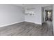 Open-concept living room with views to a bright kitchen and a gray wood-look floor at 142 Lakeview Way # 142, Oldsmar, FL 34677