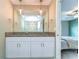 Bathroom features a double vanity with granite countertop, elegant lighting, and a mirror, offering convenience at 14477 Editors Note St, Ruskin, FL 33573