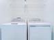 Convenient laundry room setup with a white washer, dryer, and shelving for storage at 14477 Editors Note St, Ruskin, FL 33573