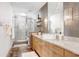 Bathroom featuring a glass walk-in shower, gray tile, white vanity, and stylish light fixtures at 175 2Nd S St # 1014, St Petersburg, FL 33701