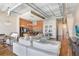 Bright open-concept living space featuring exposed ceiling pipes, hardwood floors and a dining room table at 175 2Nd S St # 1014, St Petersburg, FL 33701