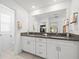 Bathroom featuring a double vanity with granite countertops, and a view to the commode and closet at 17950 Beaming Rays Ln, Lutz, FL 33558