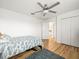 Bright bedroom with hardwood floors, a ceiling fan, and a convenient closet space at 17950 Beaming Rays Ln, Lutz, FL 33558