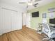Comfortable bedroom featuring wood floors, a ceiling fan, closet, and a wall-mounted television at 17950 Beaming Rays Ln, Lutz, FL 33558
