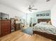 Cozy bedroom with modern furnishings, hardwood floors, and a ceiling fan for added comfort at 17950 Beaming Rays Ln, Lutz, FL 33558