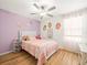 Inviting bedroom with colorful wall decor, hardwood floors, and a ceiling fan at 17950 Beaming Rays Ln, Lutz, FL 33558