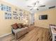 Upstairs bonus room boasts a Gathering photo gallery wall, seating, and workspace at 17950 Beaming Rays Ln, Lutz, FL 33558
