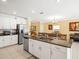 Open kitchen featuring stainless steel appliances, granite countertops, and island seating at 17950 Beaming Rays Ln, Lutz, FL 33558