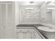 Bathroom boasts a large mirror, white cabinets with dark countertops, and an oval sink at 19029 Us Highway 19 N # 2-17, Clearwater, FL 33764