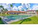 Shuffleboard court with benches surrounded by lush landscaping and community buildings under a sunny sky at 19029 Us Highway 19 N # 2-17, Clearwater, FL 33764