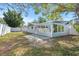 Expansive backyard featuring a paved patio, lush green grass, and a white picket fence, ideal for recreation at 1972 Sourwood Blvd, Dunedin, FL 34698