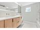 Modern bathroom featuring double sinks, custom cabinets, and tiled shower at 1972 Sourwood Blvd, Dunedin, FL 34698