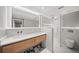 Bright bathroom features double vanity with sleek countertop, modern fixtures and a glass enclosed shower at 1972 Sourwood Blvd, Dunedin, FL 34698
