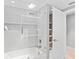 Bathroom featuring a shower over bath, large glass shower screen and linen cupboard at 1972 Sourwood Blvd, Dunedin, FL 34698