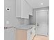 Bright laundry room with ample storage space, featuring modern cabinets and a convenient countertop for folding at 1972 Sourwood Blvd, Dunedin, FL 34698