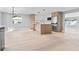 Spacious living room with modern kitchen featuring an island, stainless steel appliances, and natural light at 1972 Sourwood Blvd, Dunedin, FL 34698