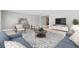 Inviting living room featuring a plush blue sofa, stylish rug, and modern entertainment center at 1972 Sourwood Blvd, Dunedin, FL 34698