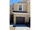 Tan townhouse featuring a one-car garage, white trim and front door along with a concrete driveway at 1973 Hawks View Dr, Ruskin, FL 33570