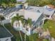 Aerial view of a light blue home surrounded by greenery and neighboring houses, showcasing its roof and landscaping at 210 15Th N Ave, St Petersburg, FL 33704