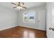 Bright bedroom with hardwood floors, ceiling fan, and white trim around the window at 210 15Th N Ave, St Petersburg, FL 33704