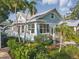 Charming home featuring blue exterior paint, manicured landscaping, and mature trees at 210 15Th N Ave, St Petersburg, FL 33704