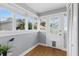 Light-filled sunroom with hardwood floors, multiple windows and a door leading outside at 210 15Th N Ave, St Petersburg, FL 33704