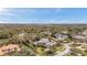 Aerial view of the home in a wooded lot showing the gray roof and solar panels at 2280 Mackenzie Ct, Clearwater, FL 33765