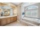 Bathroom has a soaking tub, a large mirror, and a vanity with double sinks at 2280 Mackenzie Ct, Clearwater, FL 33765
