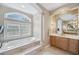 Modern bathroom with tub, elegant marble accents, and ample natural light at 2280 Mackenzie Ct, Clearwater, FL 33765