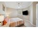 Well-lit bedroom featuring a ceiling fan, large TV, and comfortable queen bed with striped bedding at 2280 Mackenzie Ct, Clearwater, FL 33765