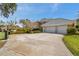 Wide concrete driveway leads to a three-car garage, and a basketball hoop on the side at 2280 Mackenzie Ct, Clearwater, FL 33765