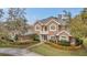 Elegant two-story home with a charming balcony, well-manicured landscaping, and a brick-paved driveway at 2280 Mackenzie Ct, Clearwater, FL 33765