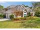 Elegant home exterior with a well-maintained lawn, beautiful landscaping, and a three-car garage at 2280 Mackenzie Ct, Clearwater, FL 33765