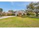 Charming two-story home with a well-manicured lawn, mature trees, and a spacious driveway leading to the garage at 2280 Mackenzie Ct, Clearwater, FL 33765