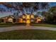 Exterior twilight view of a two-story home featuring landscape lighting at 2280 Mackenzie Ct, Clearwater, FL 33765
