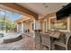 An inviting outdoor patio features a lounge chair, table with chairs, and a view of a pool beyond a screened enclosure at 2280 Mackenzie Ct, Clearwater, FL 33765
