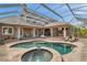 Resort style pool and spa is encased in a screened lanai with an outdoor kitchen and multiple lounging areas at 2280 Mackenzie Ct, Clearwater, FL 33765